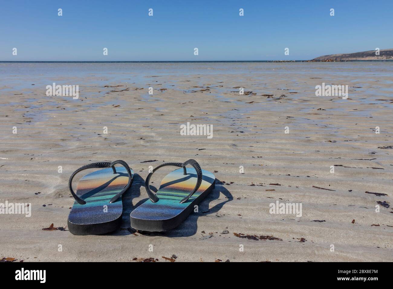 A pair of flip flops on a deserted sandy beach in australia Stock Photo ...