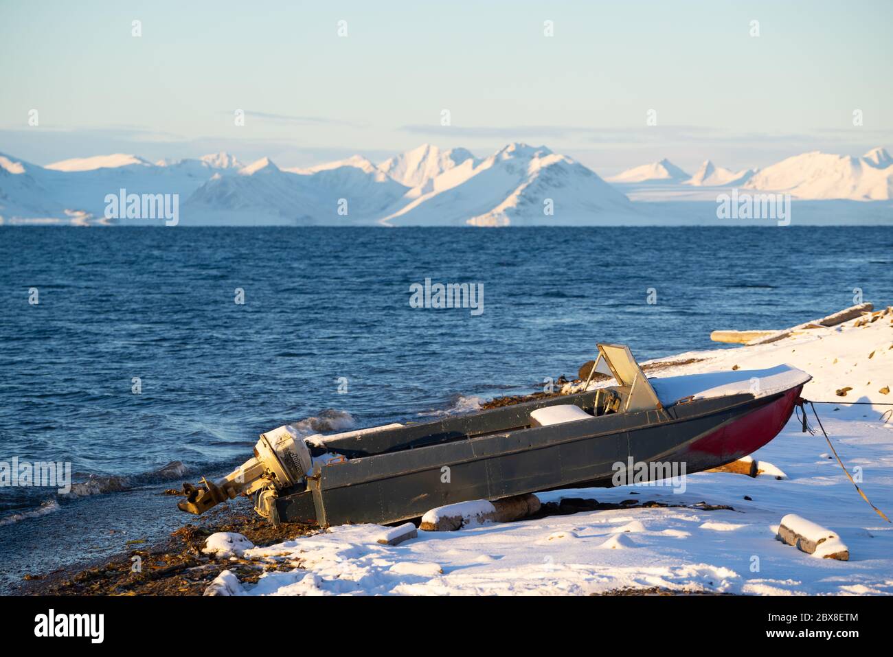 Old boat on the rocky beach close to the Russian settlement Barentsburg Stock Photo