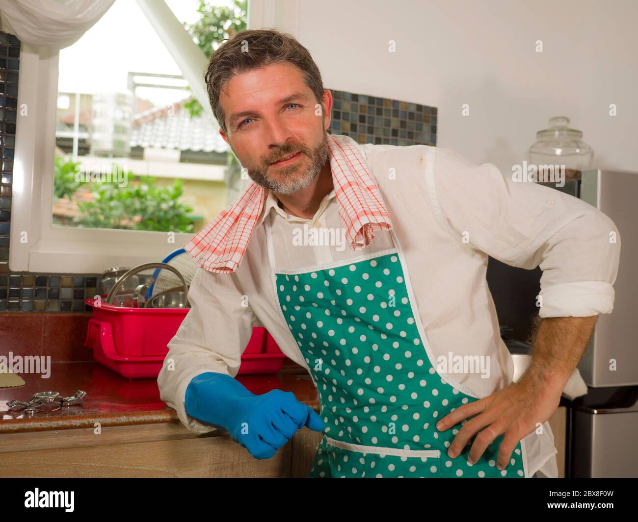 Portrait of smiling man cleaning the kitchen worktop at home Stock Photo -  Alamy