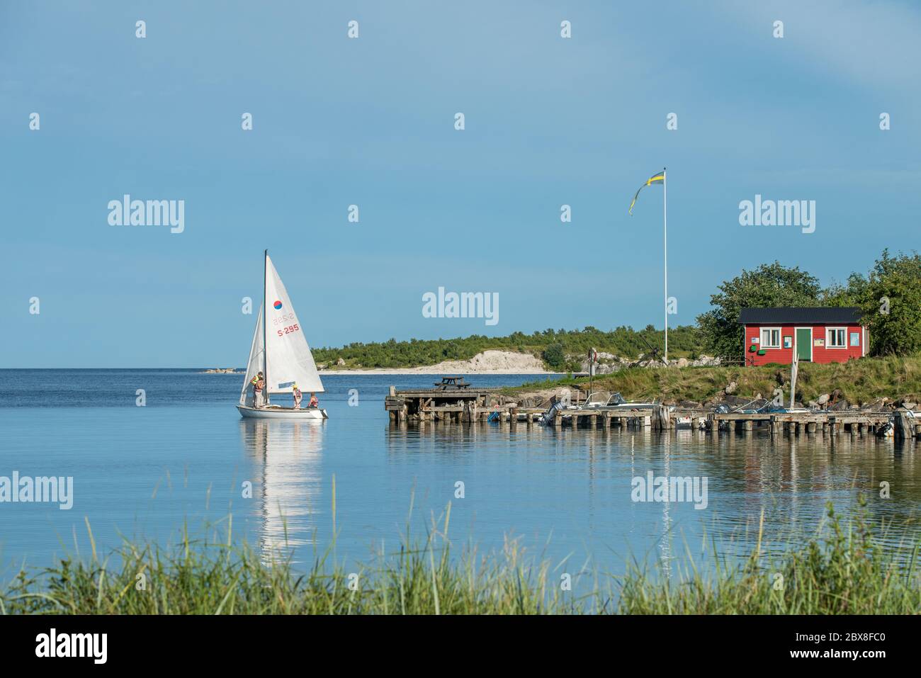 Traditional summer cottage and sailboat at St Olofsholm on Swedish Baltic sea island Gotland Stock Photo