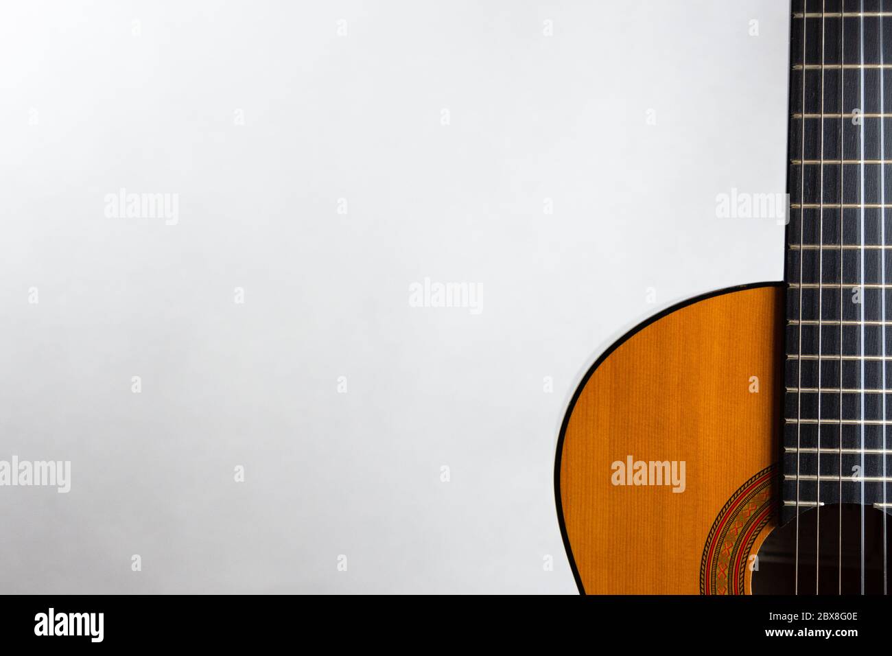 Acoustic guitar placed on the right side in landscape format on a light