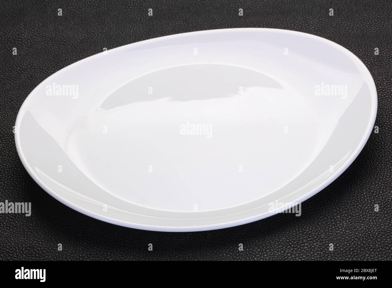 Empty white plate over black background Stock Photo - Alamy
