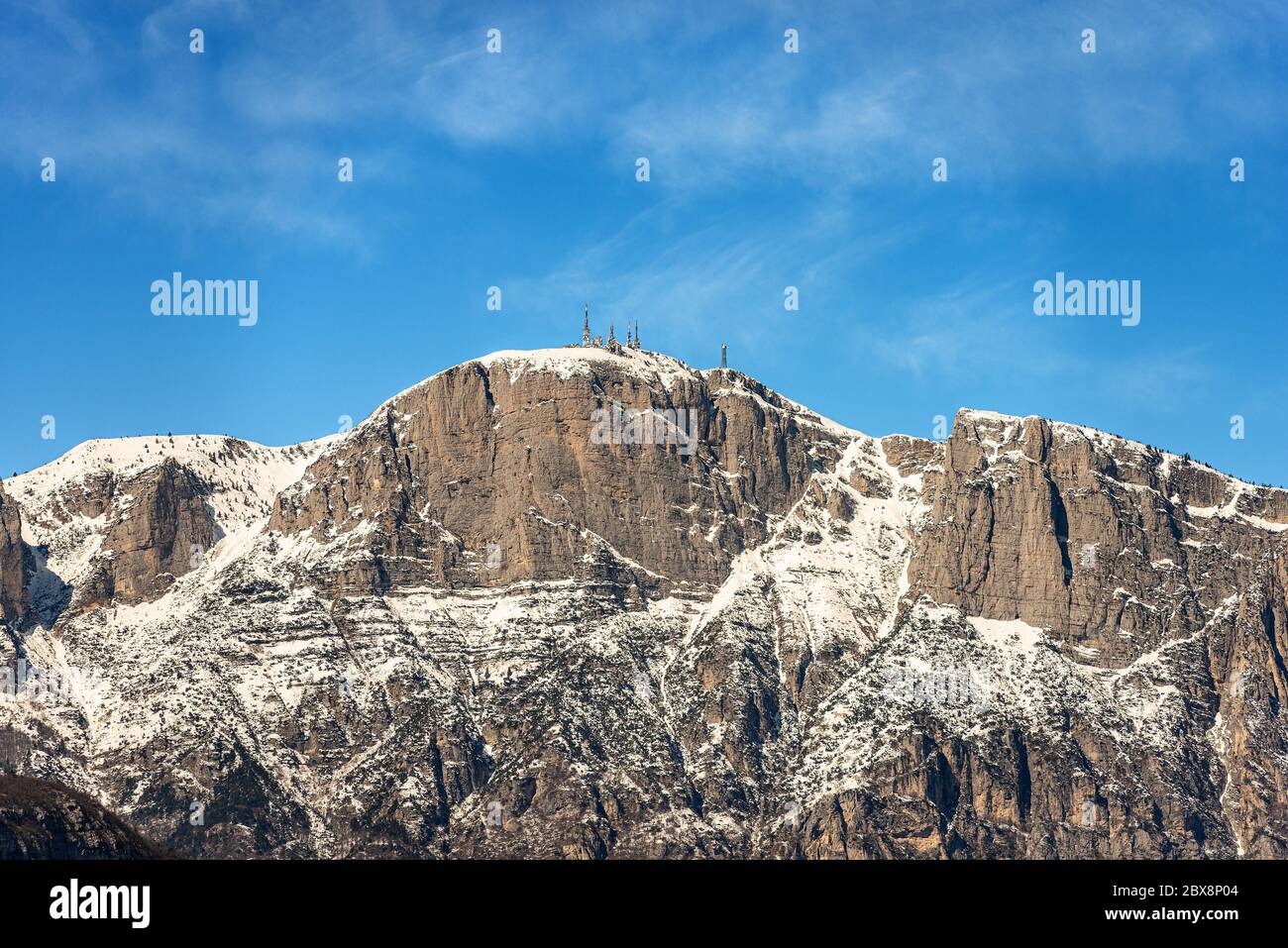 Peak of the Paganella or cima Roda (2125 m), snow caped Alps with the antennas of the weather station, seen from the Trento, Trentino, Italy. Stock Photo