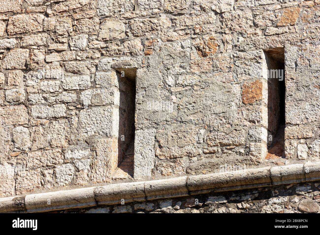 Close-up of a medieval castle wall with two arrowslits or loopholes. Castello del Buonconsiglio or Castelvecchio in Trento city. Trentino Alto Adige. Stock Photo