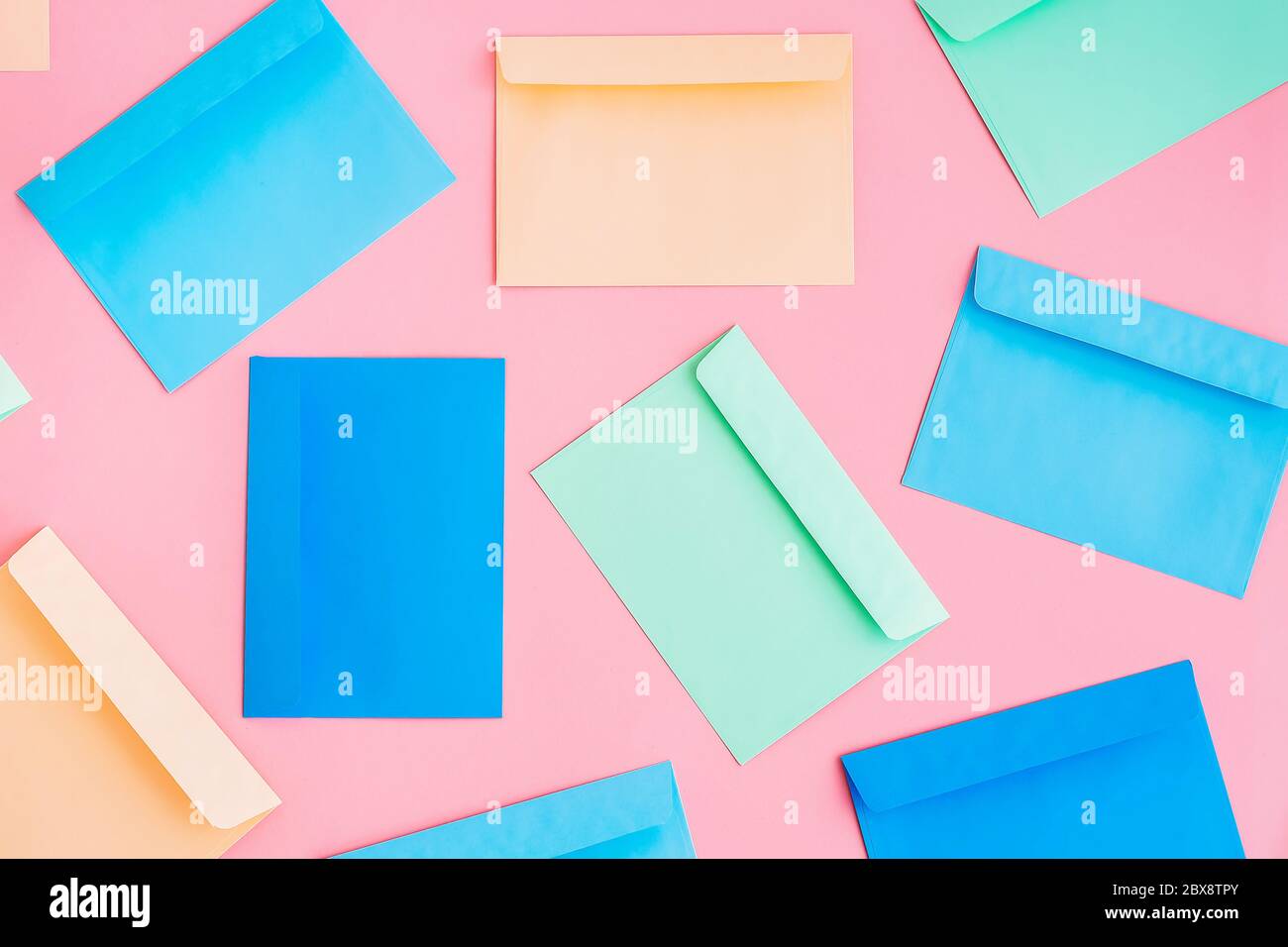 Pattern of colorful correspondence envelopes on pink background. Top view. Stock Photo