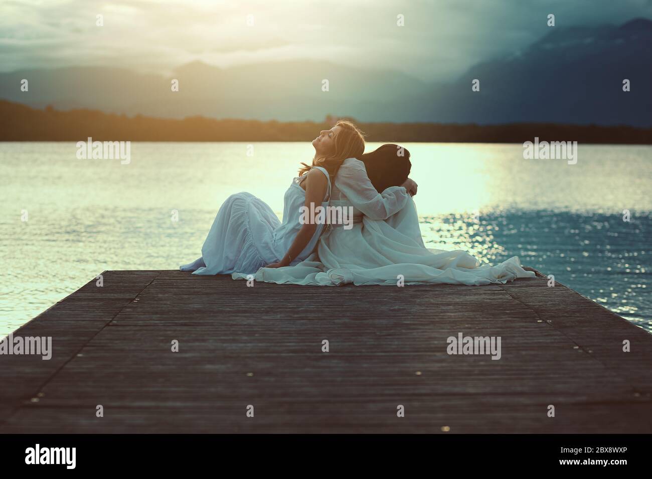 Two women sharing sunset light . Surreal and ethereal Stock Photo