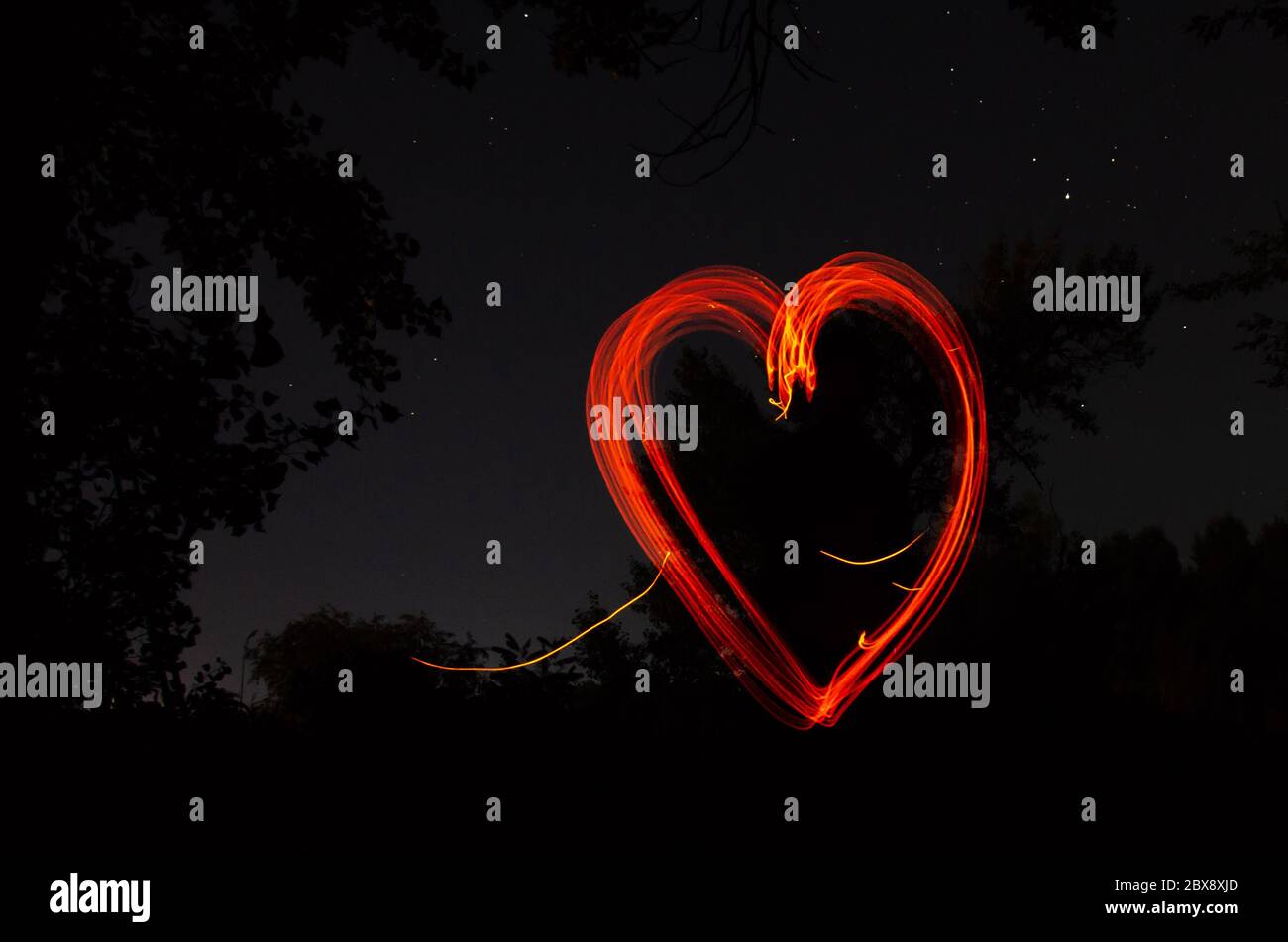 Red heart on black night background. Heart drawn by fire on dark  background. Love, romantic and festival concept Stock Photo - Alamy