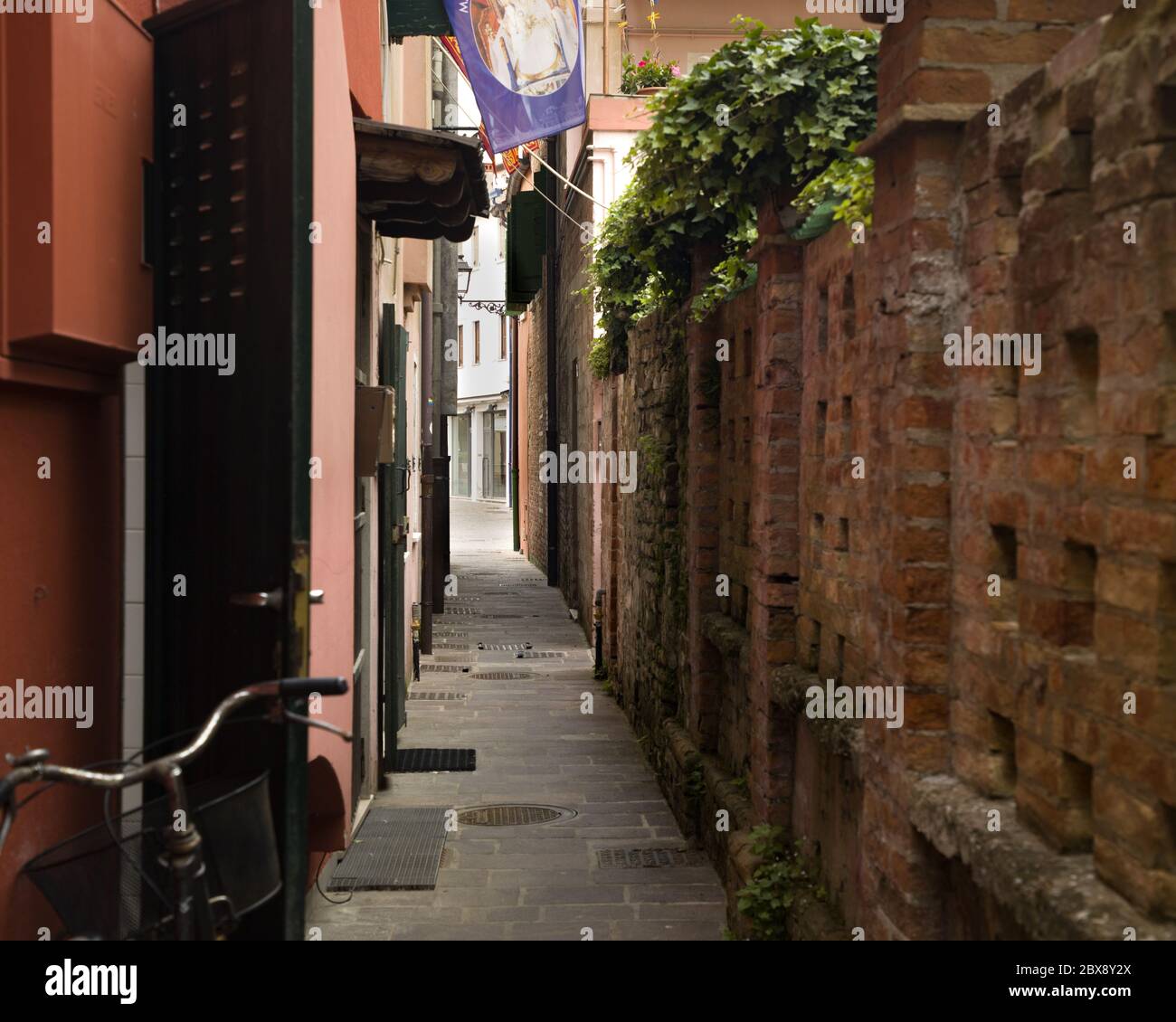 Tourism in Veneto and point of interest among the narrow alleys  and maritme houses to Caorle seaport with bicycles  and colored houses. Stock Photo