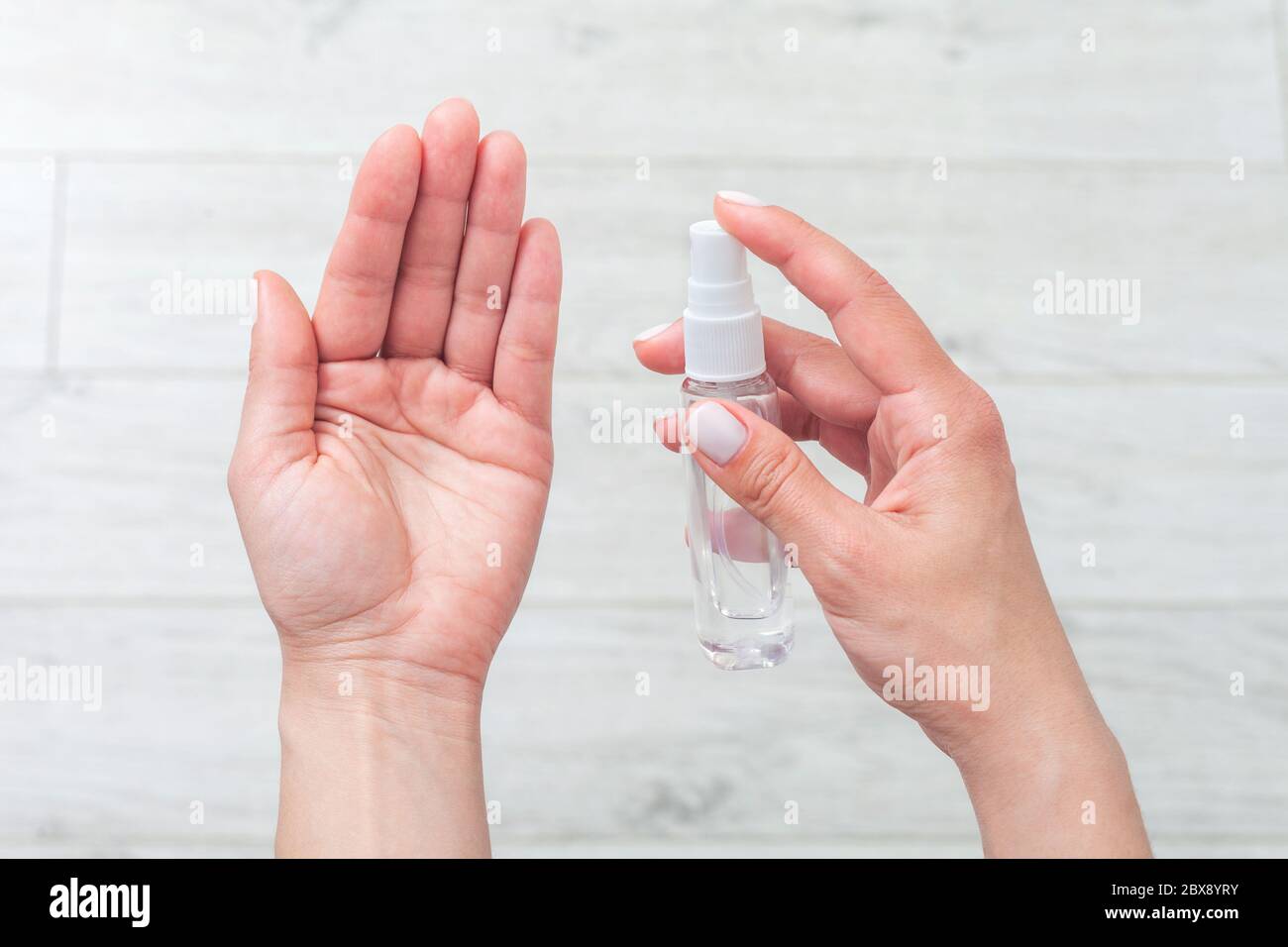 Hand disinfection. Lady's hand takes alcohol disinfectant spray on her