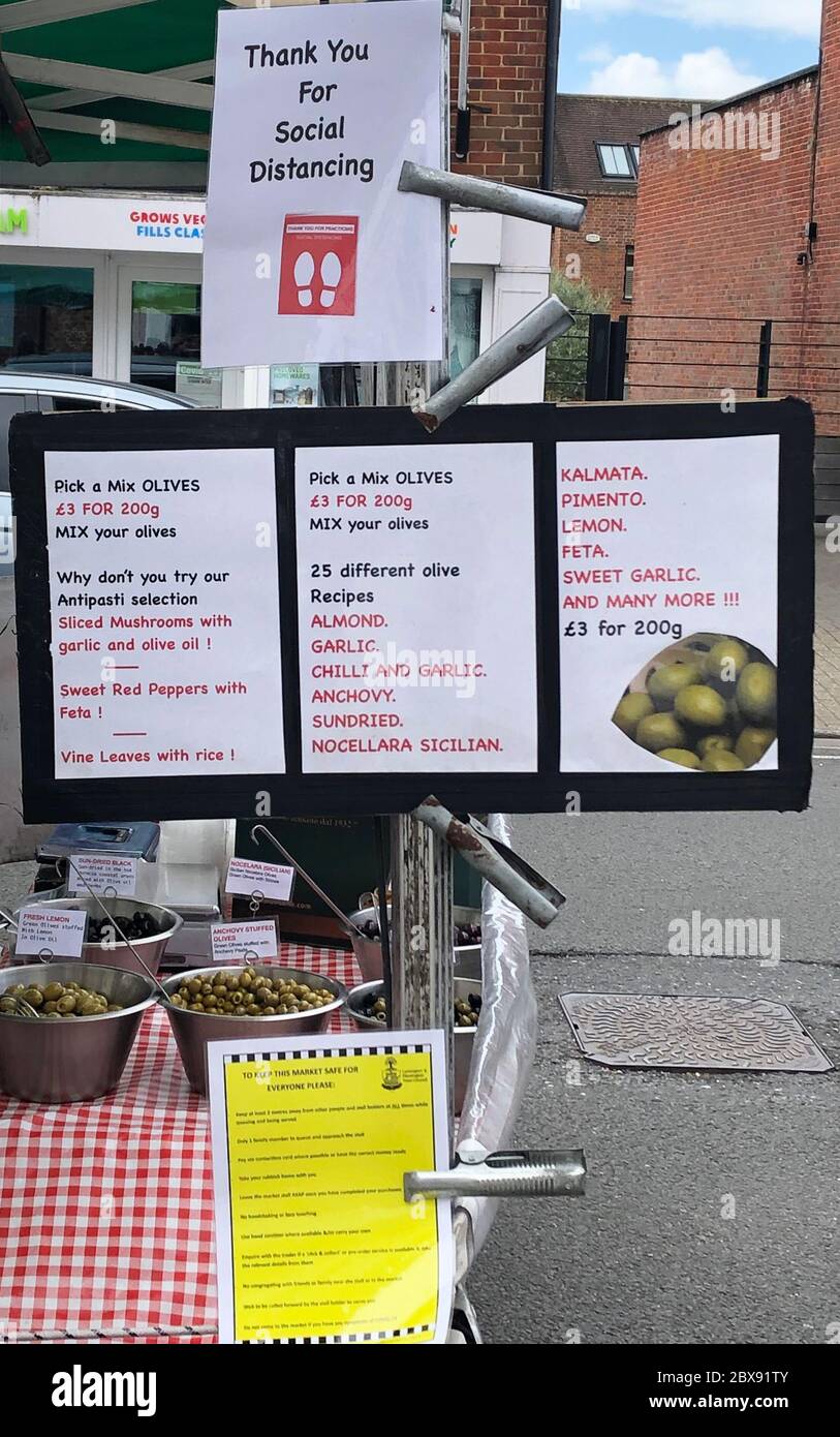A sign reminding people to social distance at the Saturday market in Lymington, Hampshire, which has re-opened more than two months after closing in the wake of the Coronavirus crisis. Stock Photo