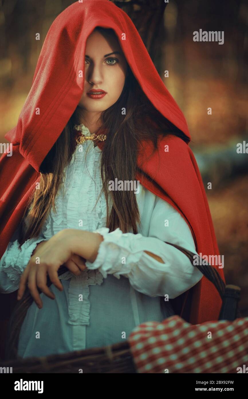 Portrait of beautiful Little Red riding hood with wicker basket in the