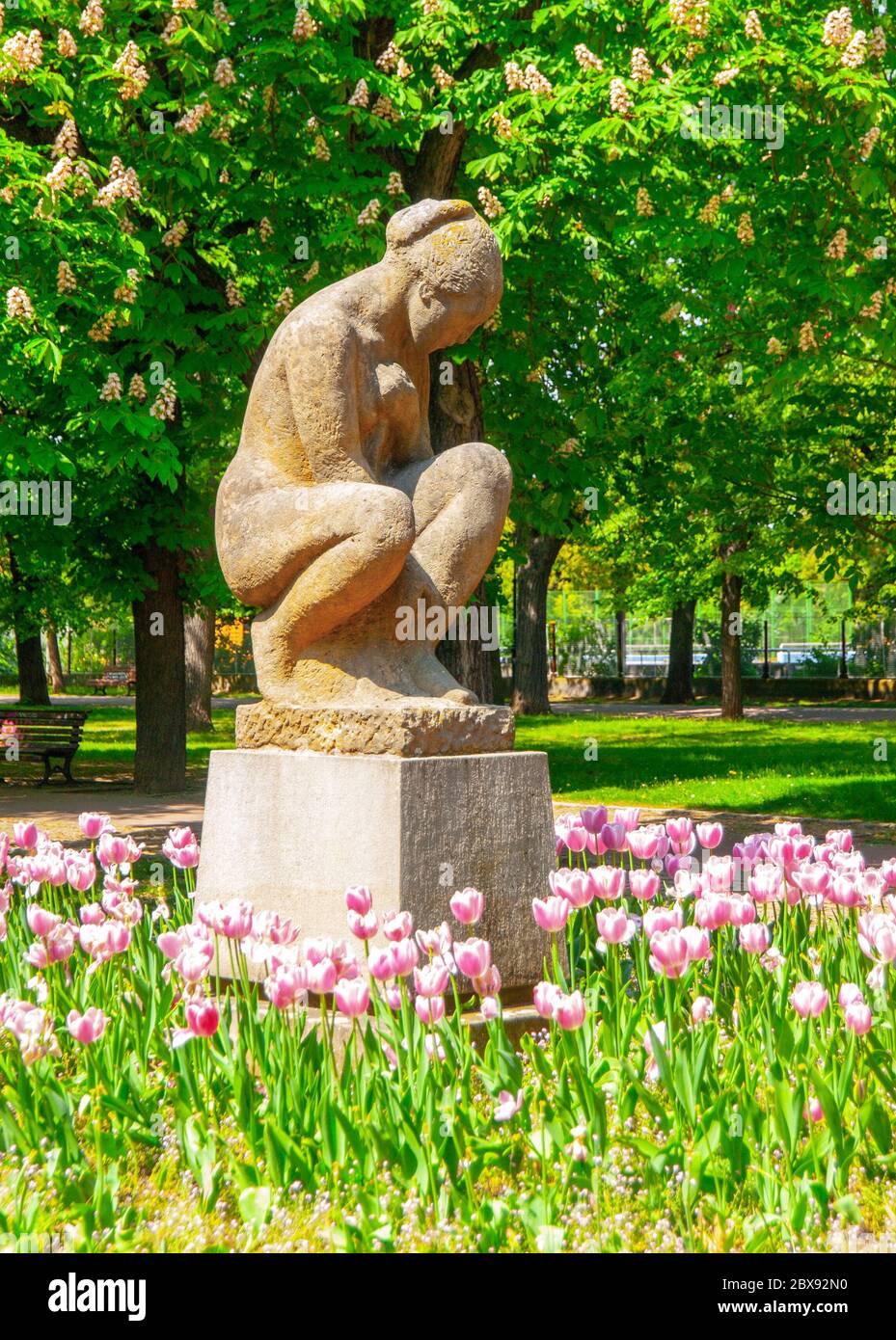 Sculpture of seated woman in Letna Park on sunny summer day with pitnk tulips, Prague, Czech Republic. Stock Photo