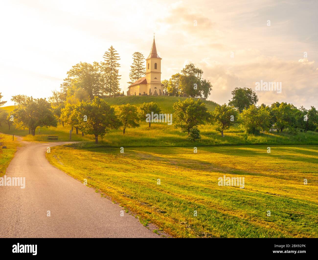 Small church in the middle of lush green spring landscape on sunny day. St. Peter and Pauls church at Bysicky near Lazne Belohrad, Czech Republic. Stock Photo