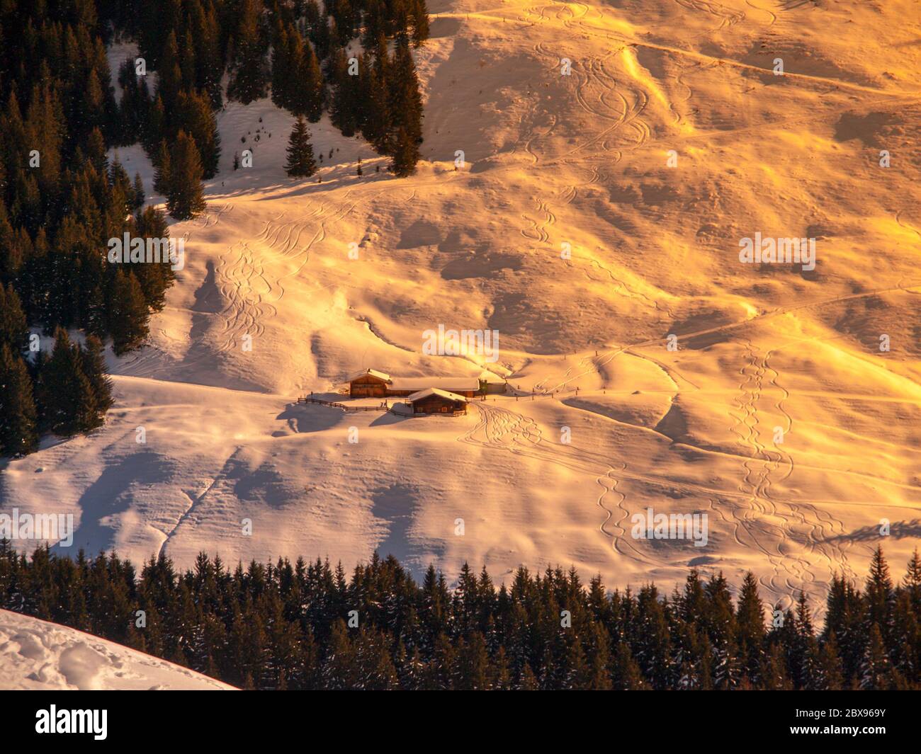 Evening view of alpine hut in the steep slope. Winter backountry ski touring area, Austrian Alps, Europe. Stock Photo