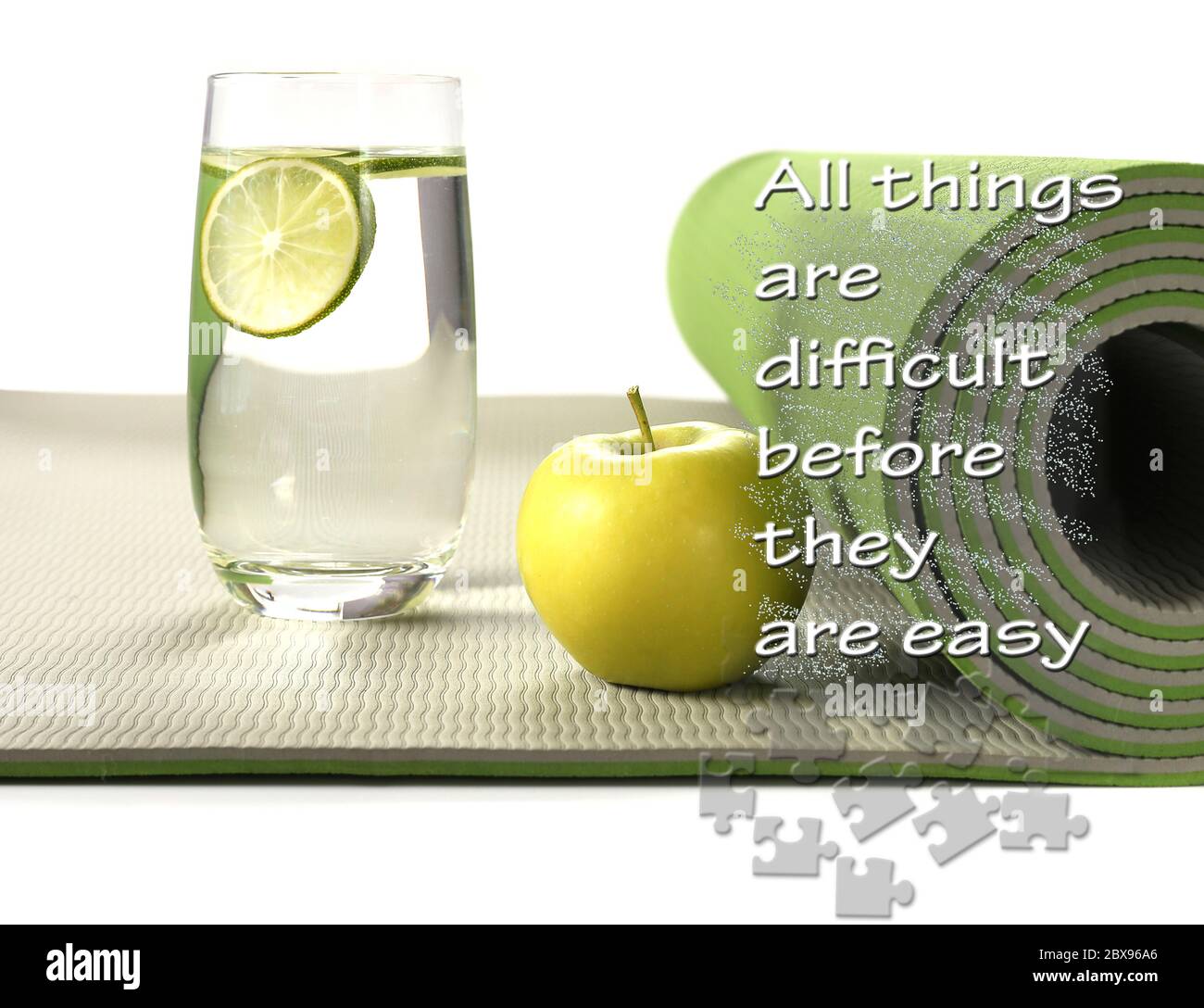 Green yoga mat with apple and glass of water with lemon on white background. Fitness motivation quote All things are difficult before they are easy. Healthy life concept Stock Photo