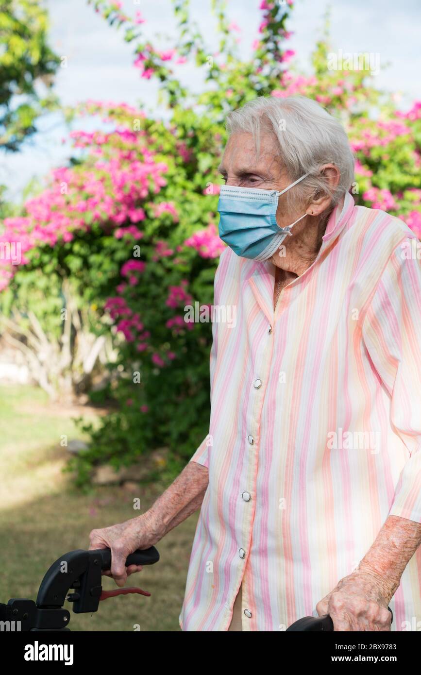 Elderly lady staying healthy wearing mask outdoors Stock Photo