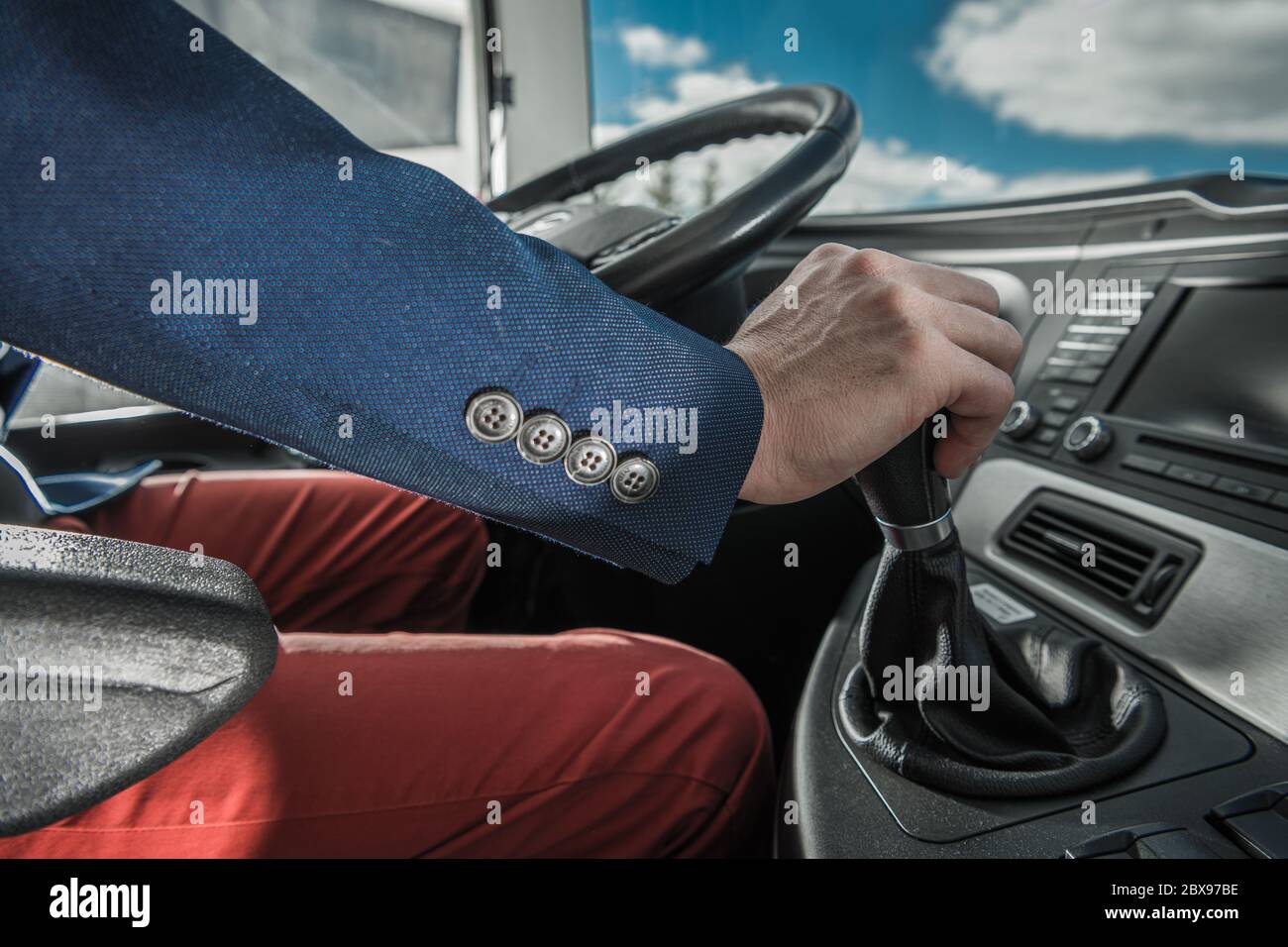 Elegant Caucasian Bus Driver Behind Coach Steering Wheel. Close Up
