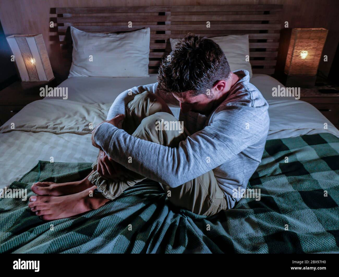 indoors portrait of young desperate and depressed man at home bedroom