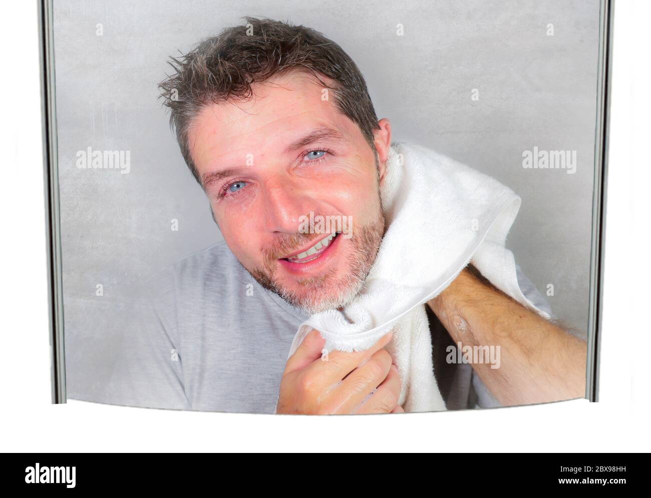 young happy and attractive man using towel drying face after washing