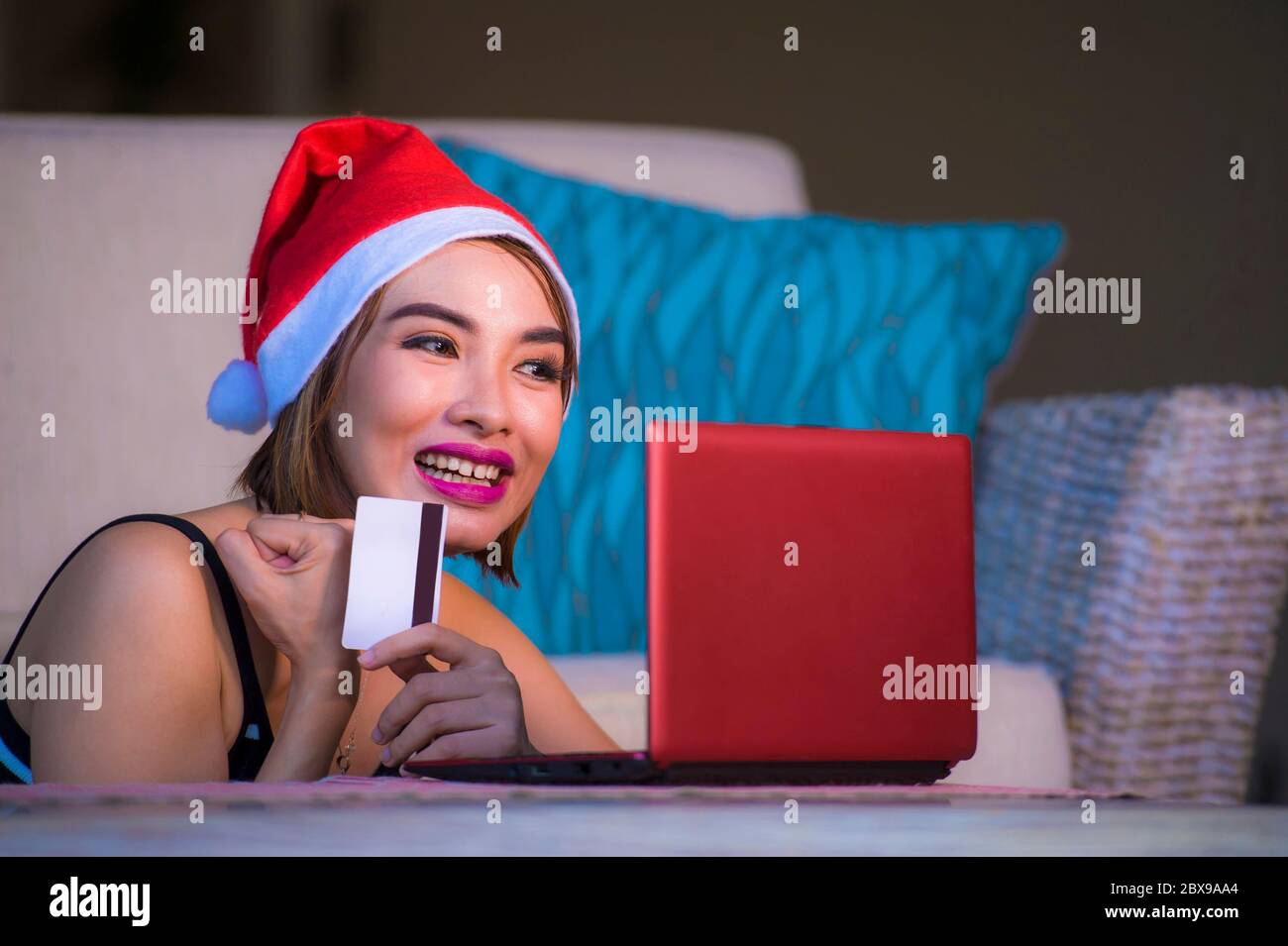 young happy and beautiful woman relaxed at home couch in Santa hat ...