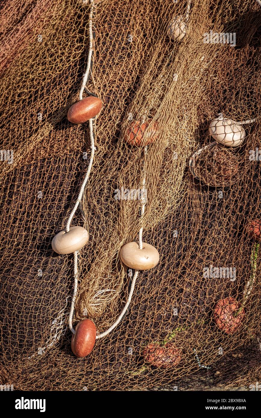 Closeup of a pile of fishing nets with a white rope and cork floats