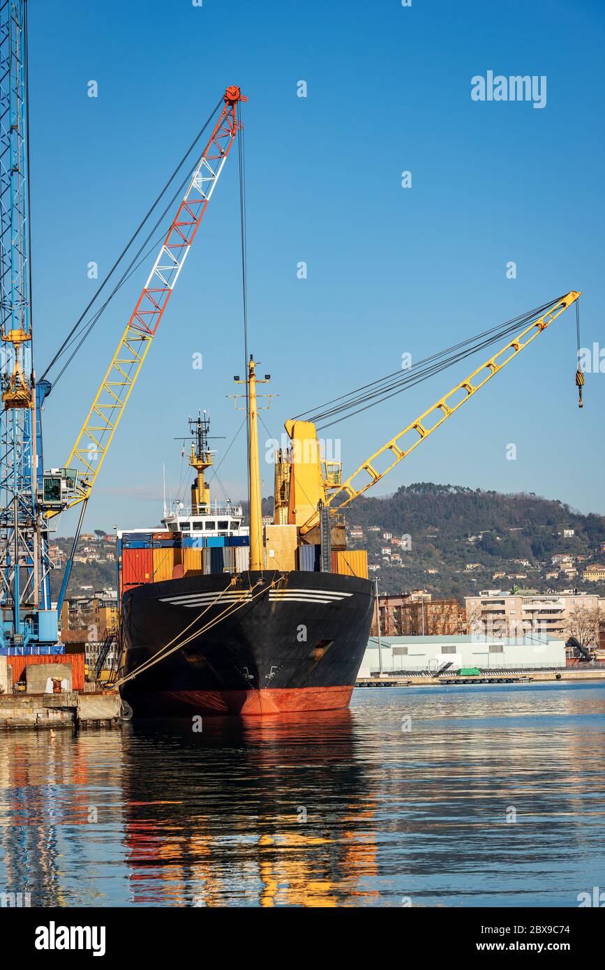 Container ship and cranes for unloading and loading in the seaport, Gulf of La Spezia, Liguria, Italy, Europe Stock Photo