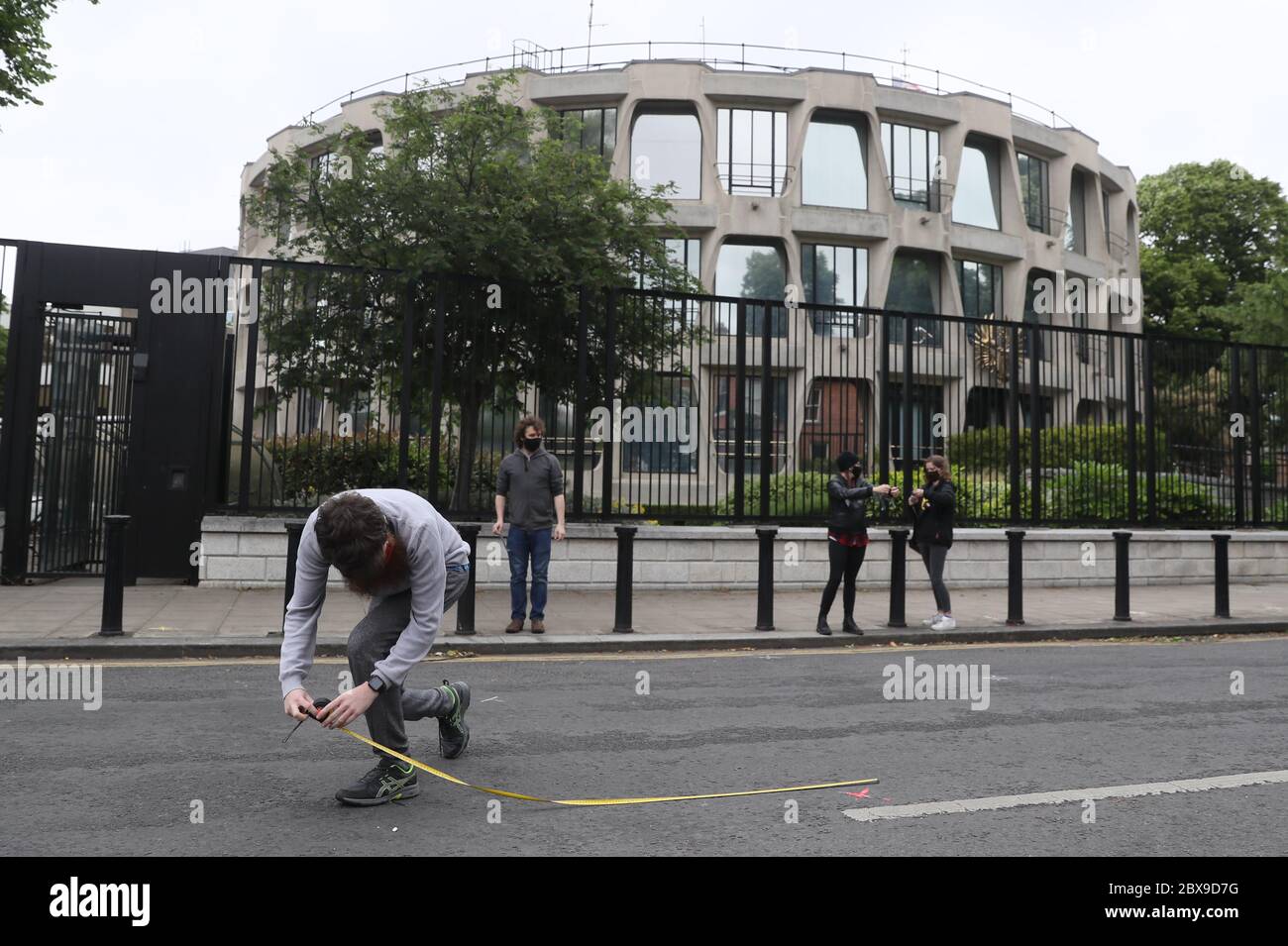 A man measures two metres to create marks outside the US Embassy in Dublin ahead of a Black Lives Matter protest rally, in memory of George Floyd who was killed on May 25 while in police custody in the US city of Minneapolis. Stock Photo