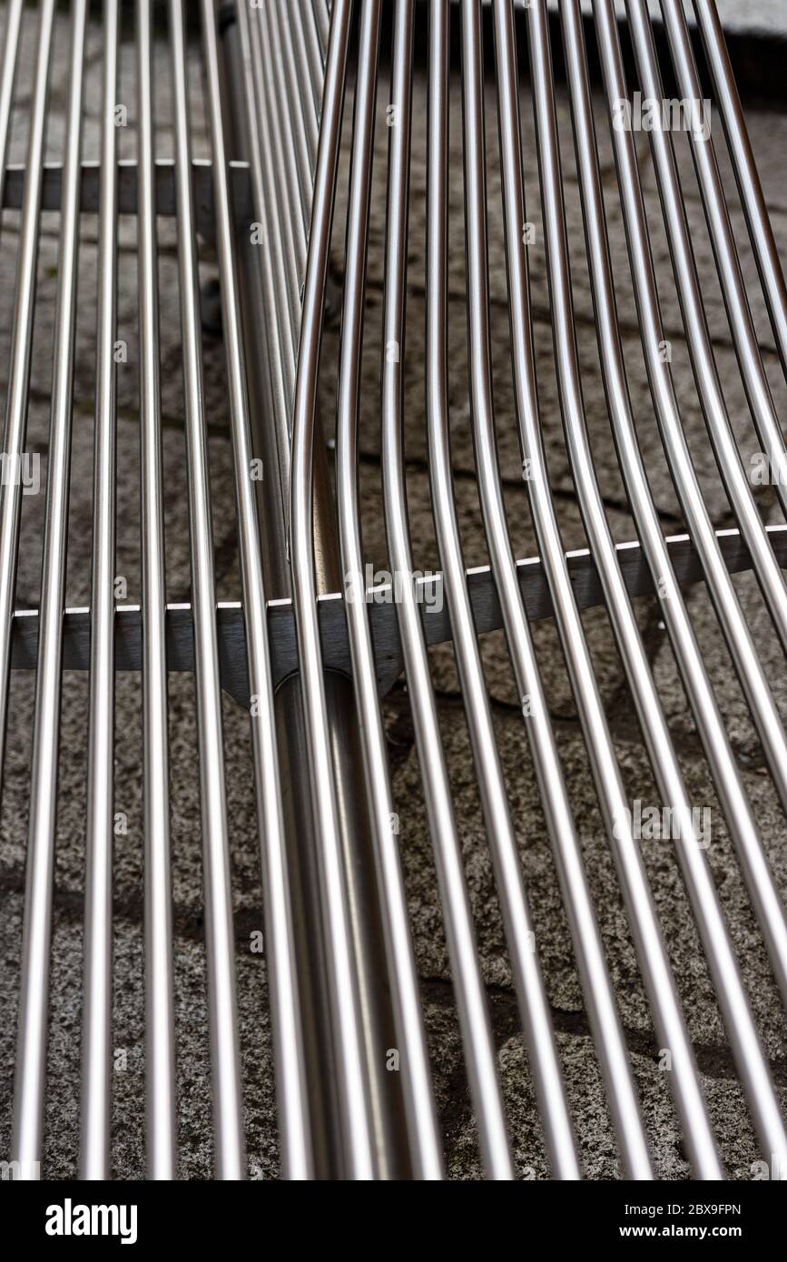 Extreme closeup of metal bars of a steel bench in downtown of Bologna