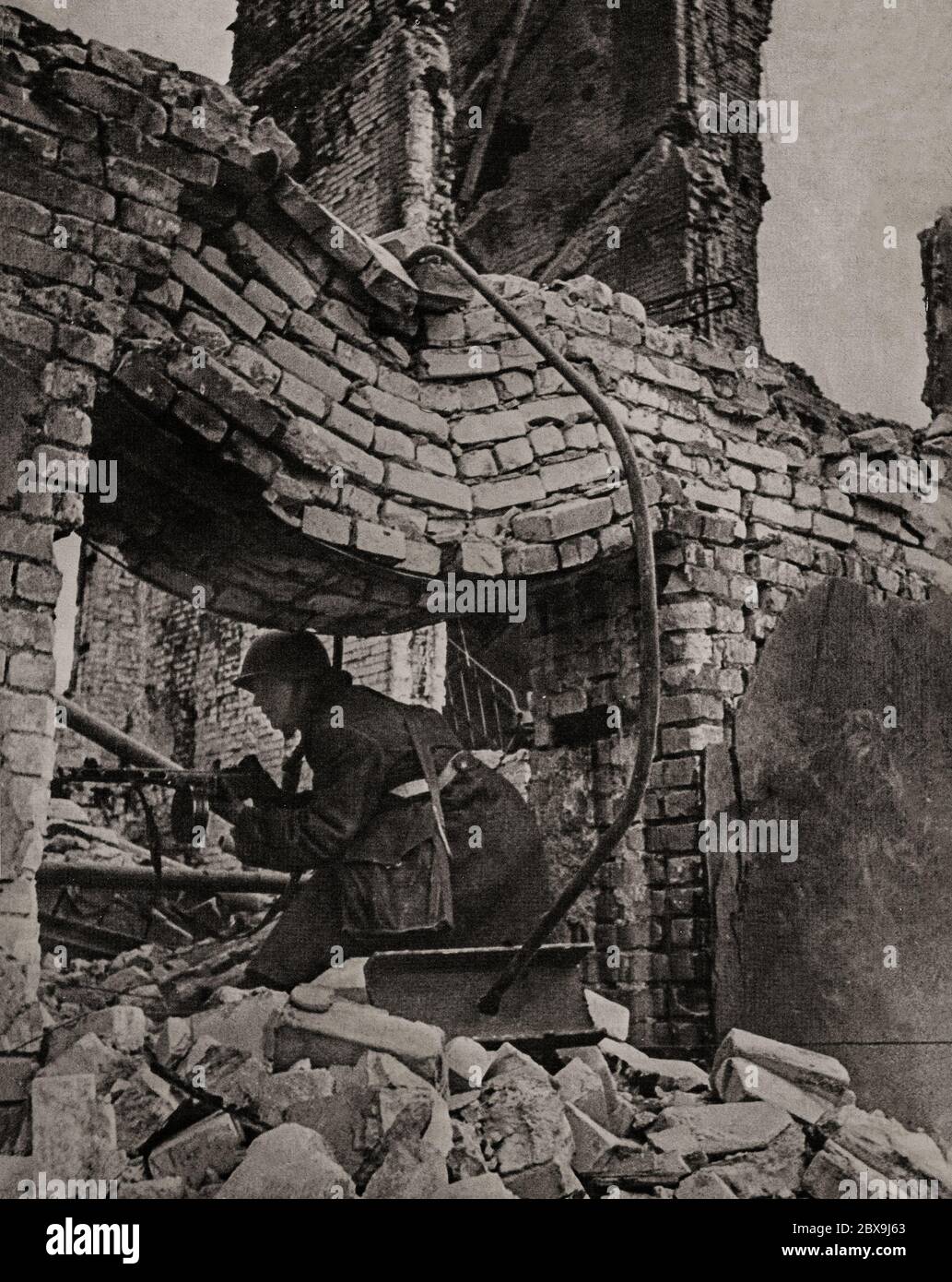 A German soldier in house to house fighting during the Battle of Stalingrad (1942-1943), when Germany and its allies fought the Soviet Union for control of the city of Stalingrad (now Volgograd) in Southern Russia. It was marked by fierce close-quarters combat and direct assaults on civilians in air raids during one of the bloodiest battles in the history of warfare, with an estimated 2 million total casualties. Stock Photo