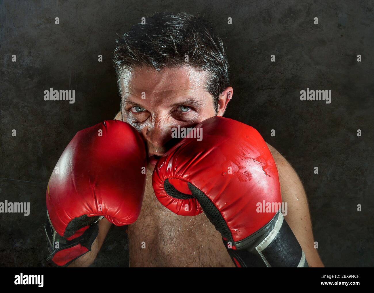 young angry and fierce sport man in boxing gloves posing in badass