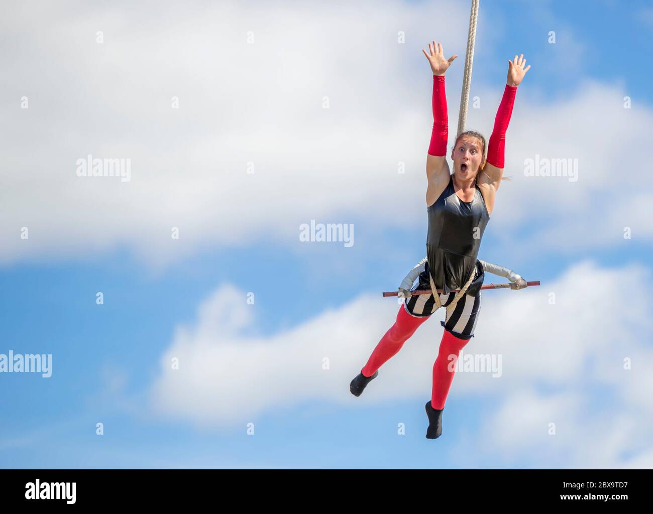 Saint John, New Brunswick, Canada - September 4, 2015: An acrobat performs at the Saint John Exhibition. She is high up on a trapeze. Stock Photo