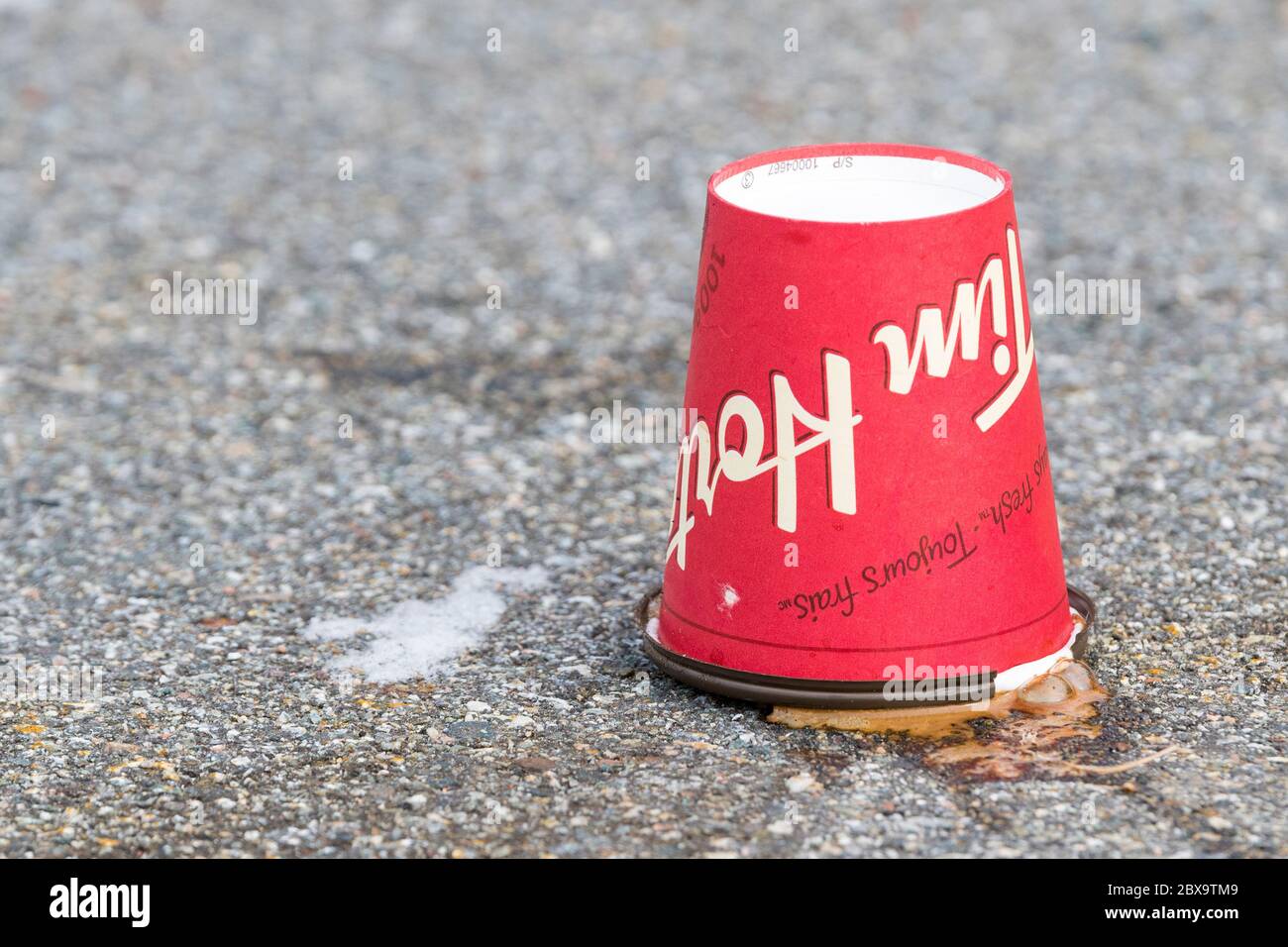 Saint John, New Brunswick, Canada - January 16, 2018: A discarded Tim Hortons coffee cup rests upside down in a parking lot. Stock Photo