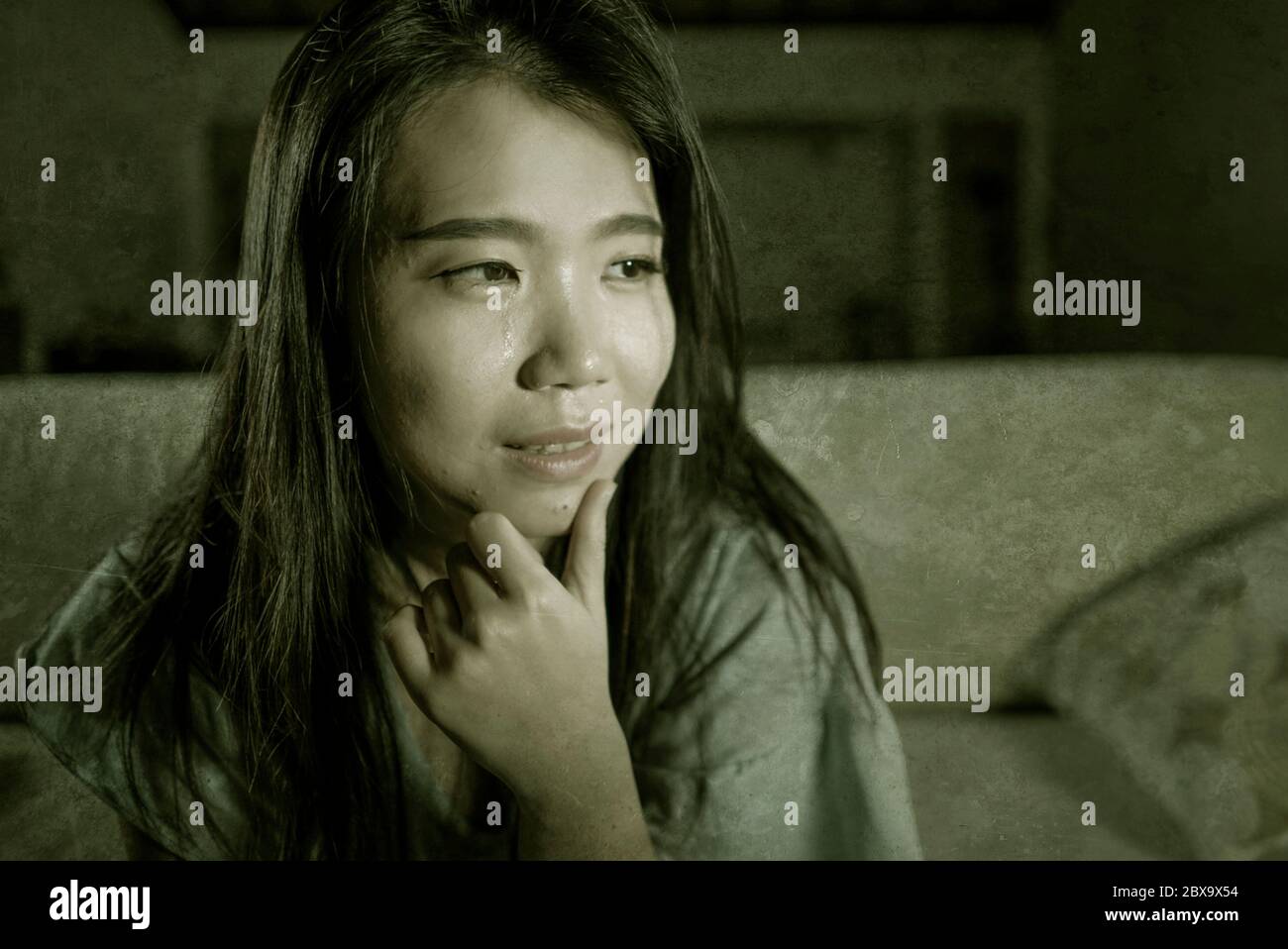 Dramatic Lifestyle Portrait Of Young Sad And Depressed Asian Japanese Woman Crying Desperate Sitting At Home Sofa Couch Suffering Depression Problem A Stock Photo Alamy