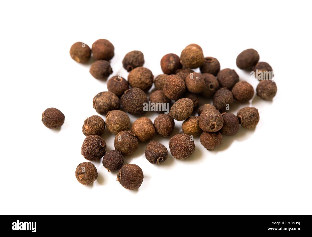 pile of dried allspice fruits isoalted on white background Stock Photo