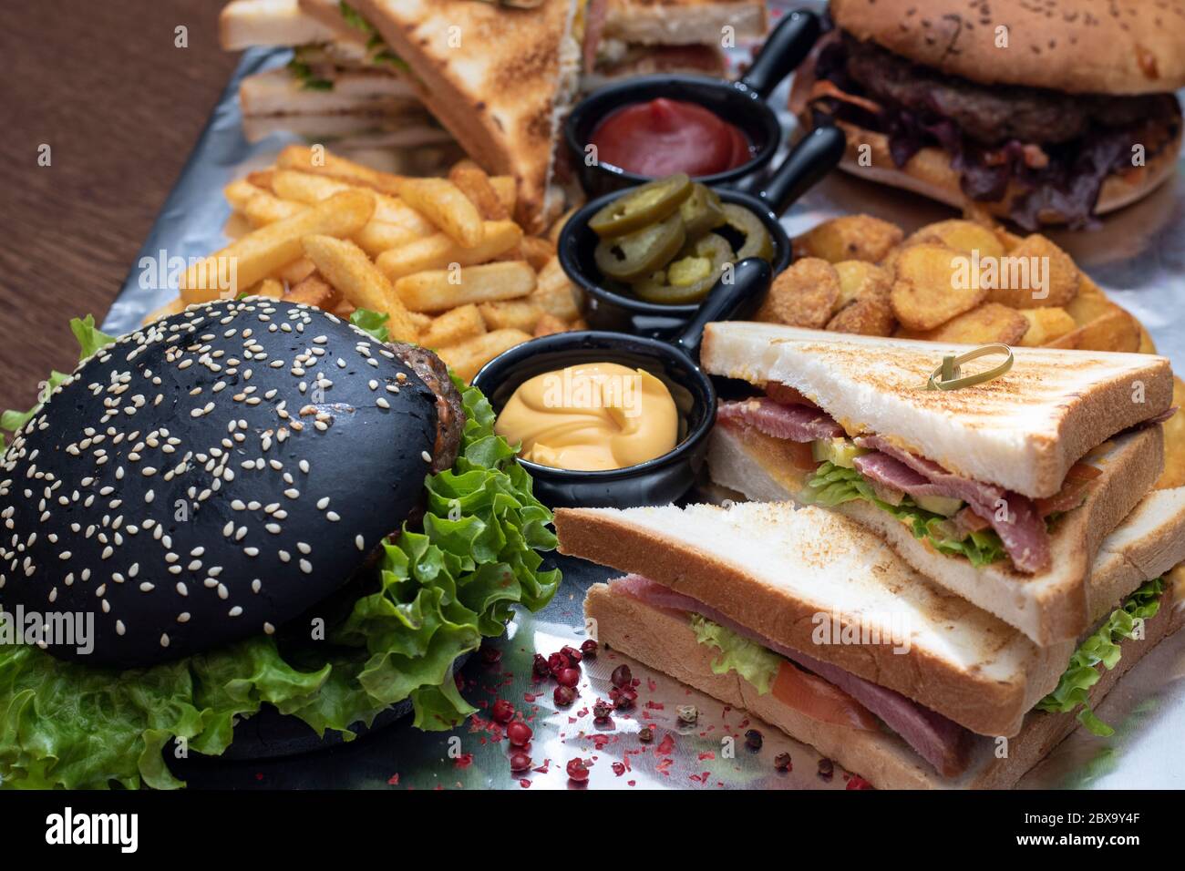 Black burger with parsley and meat. Food snack delivery. French fries  sauces. food lunch delivering Stock Photo - Alamy
