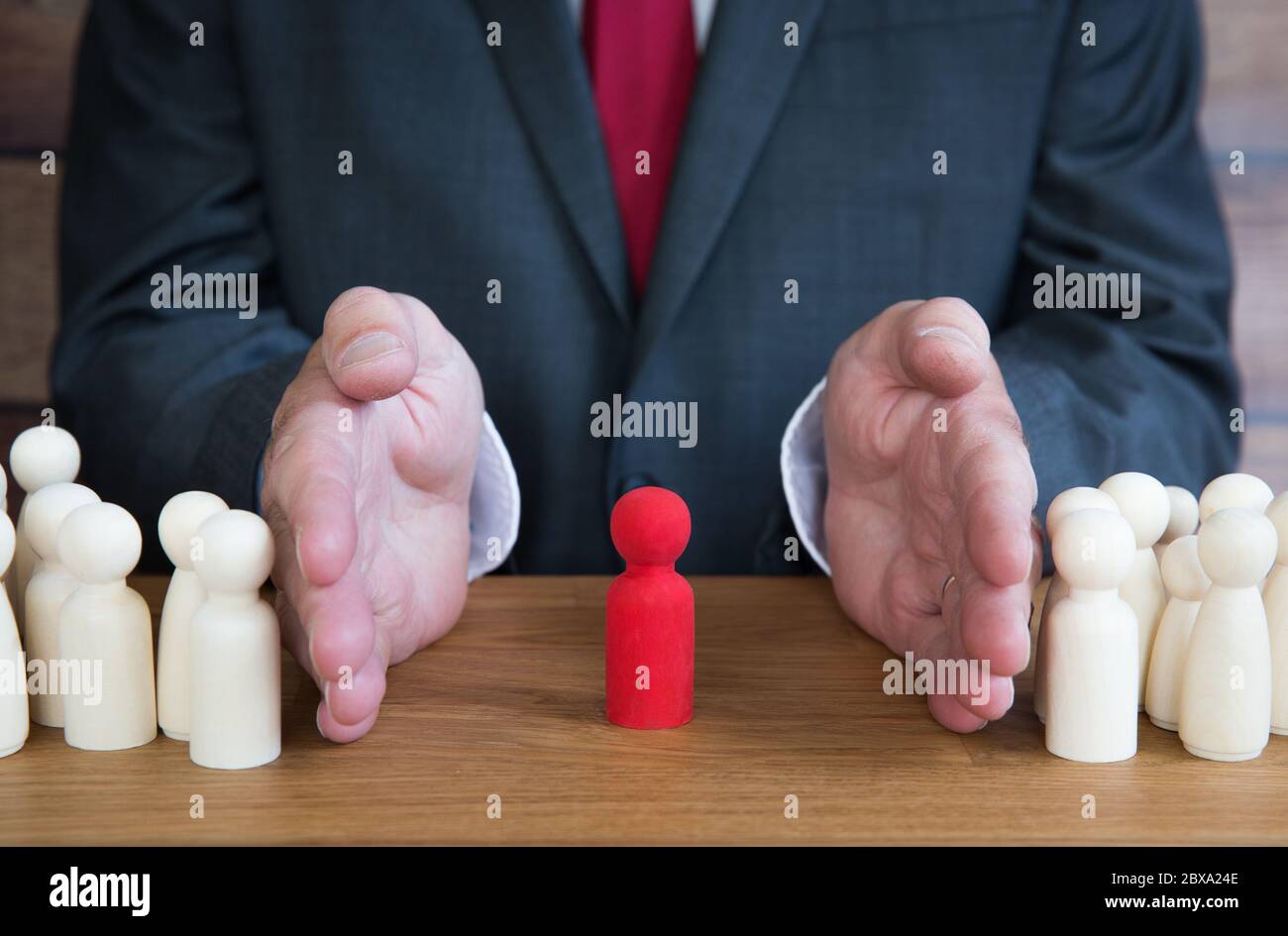 An employer or businessman separating an individual from the rest of the team because of favouritism, Coronavirus quarantine or for promotion to a man Stock Photo