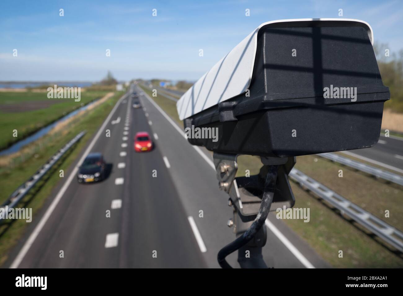 Security CCTV camera or surveillance system observes vehicular traffic on a road with