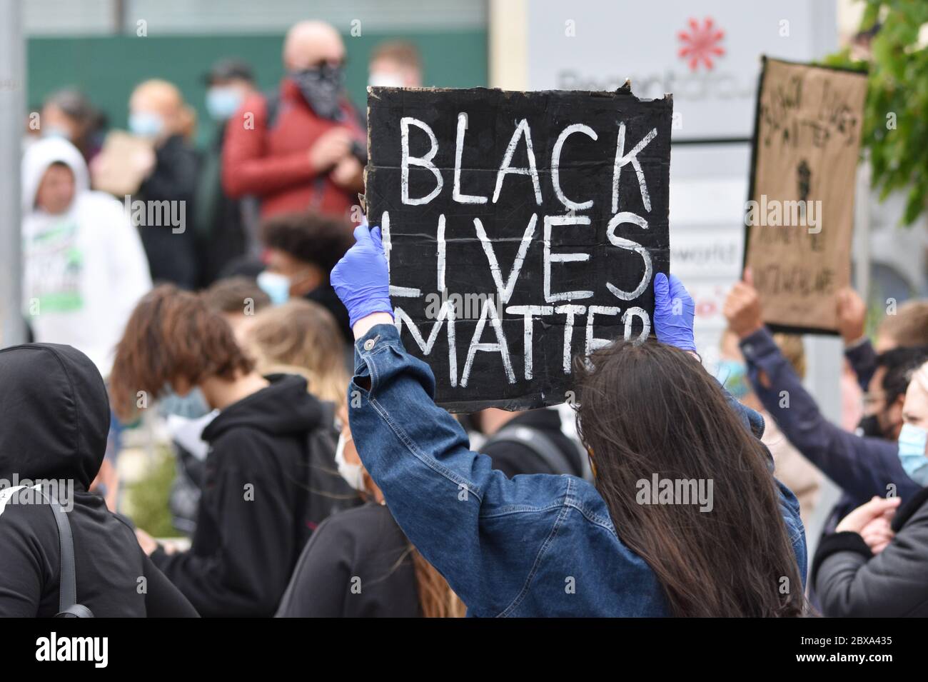 A young white woman demonstrating at a British Anti-Racism protest rally in the UK holding a sign that reads 'Black Lives Matter'. June 6 2020. Stock Photo