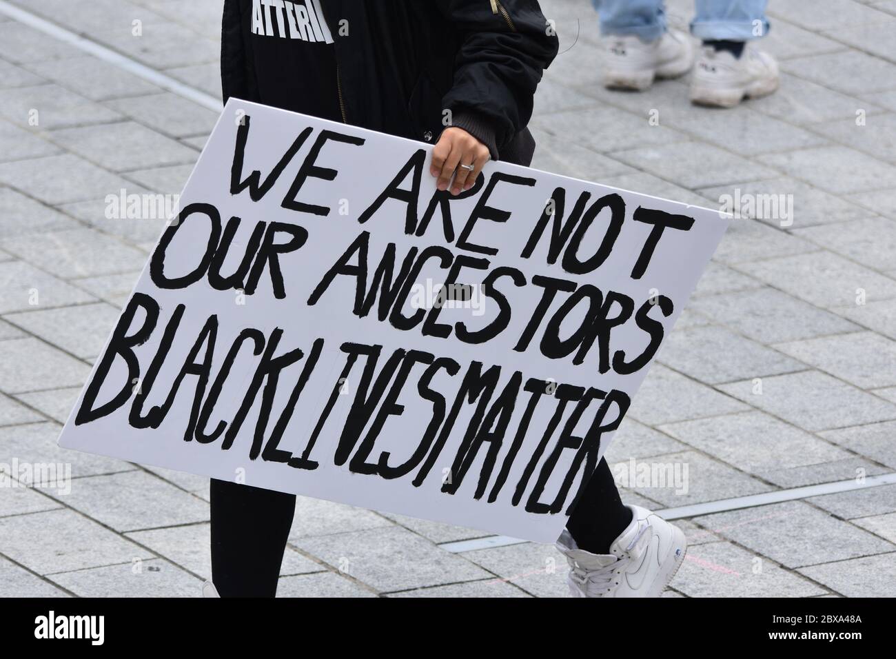 A protest sign that reads 'We Are Not Our Ancestors' being carried by an anti racism protester at a Black Lives Matter demonstration in the UK in 2020 Stock Photo