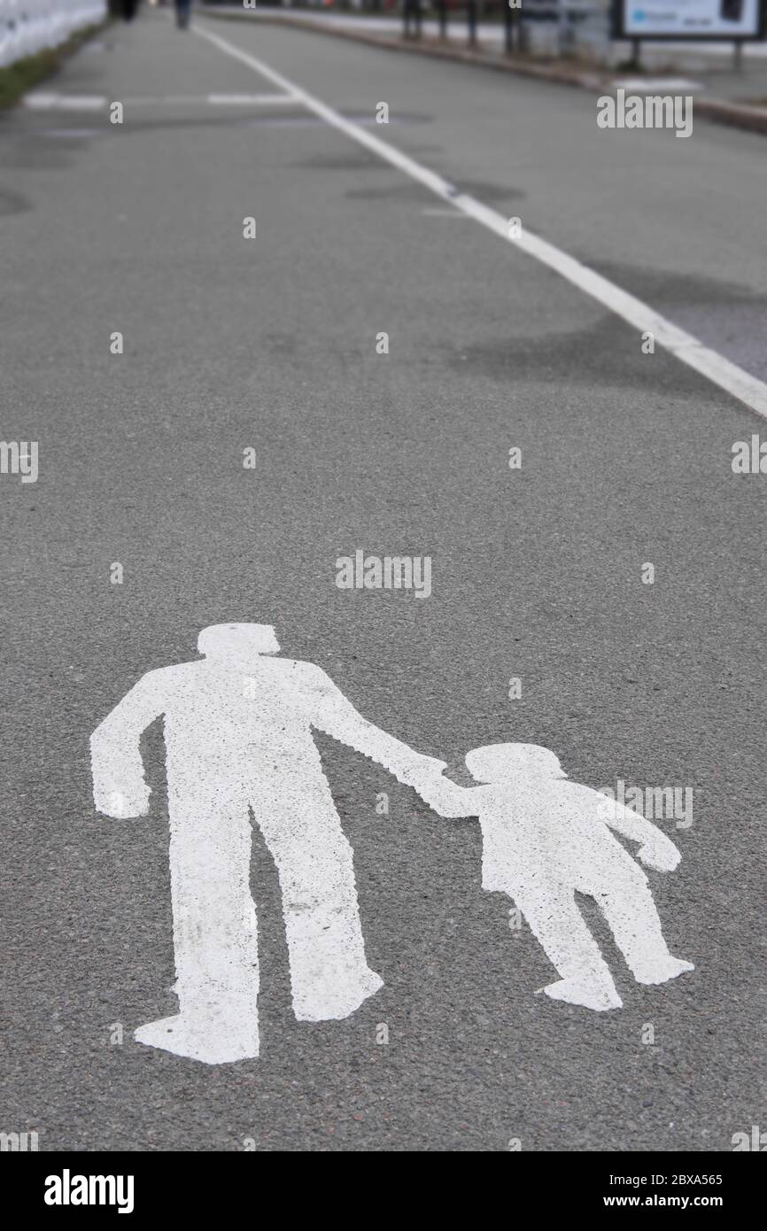 Walking man and child pavement sign painted white on a concrete way Stock Photo