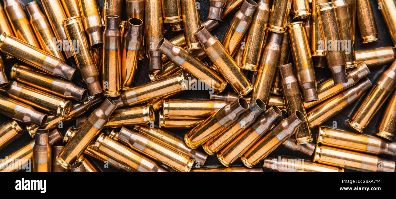 Empty cartridge cases for a carbine or rifle. Background of shiny brass