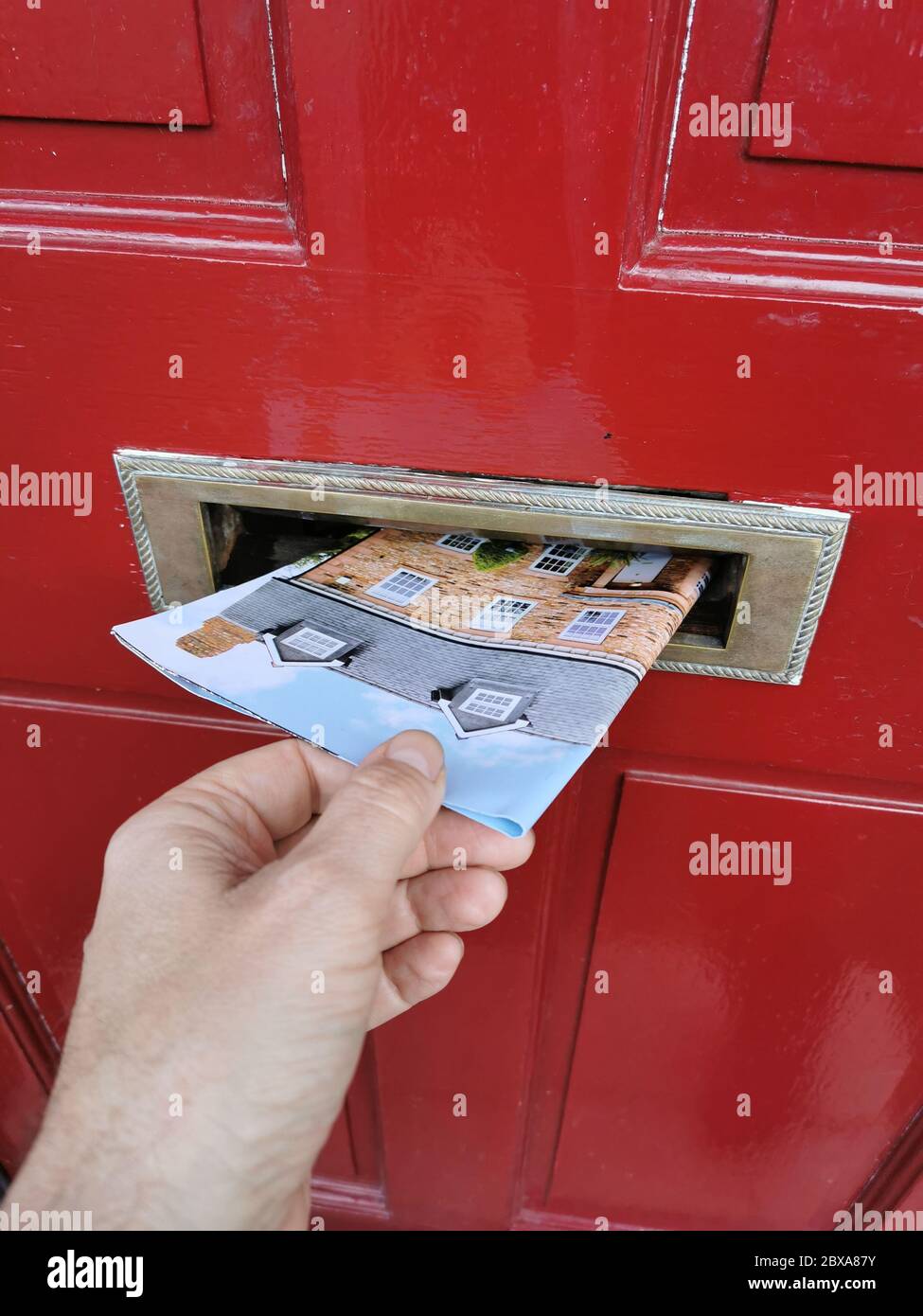 Junk mail being posted through letterbox in the UK Stock Photo