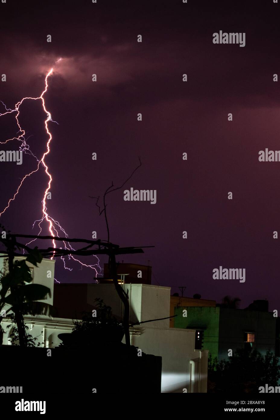 Lightning storm over the city buildings. Lightning bolt strike during a