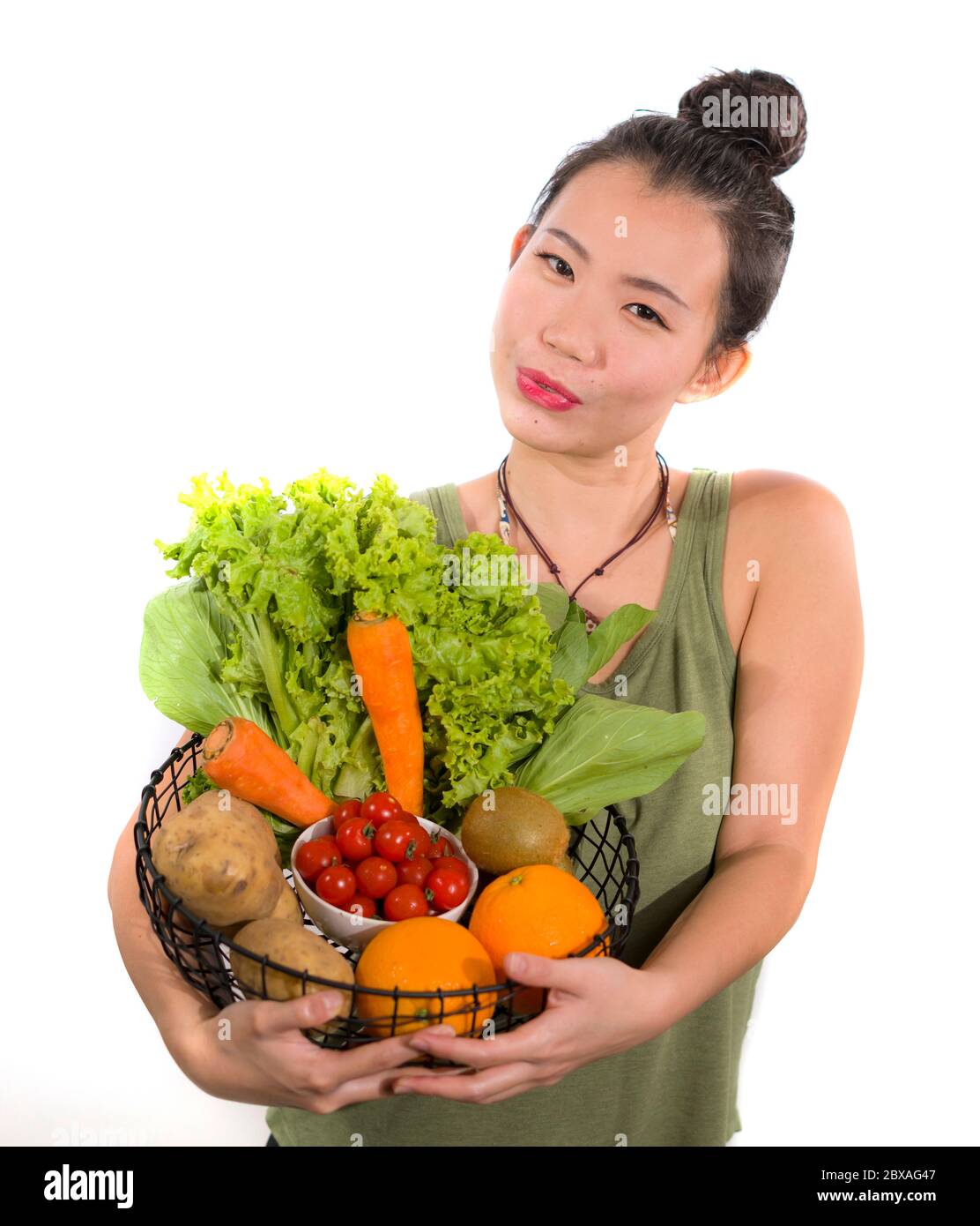 young happy and beautiful Asian Chinese woman holding basket full of ...