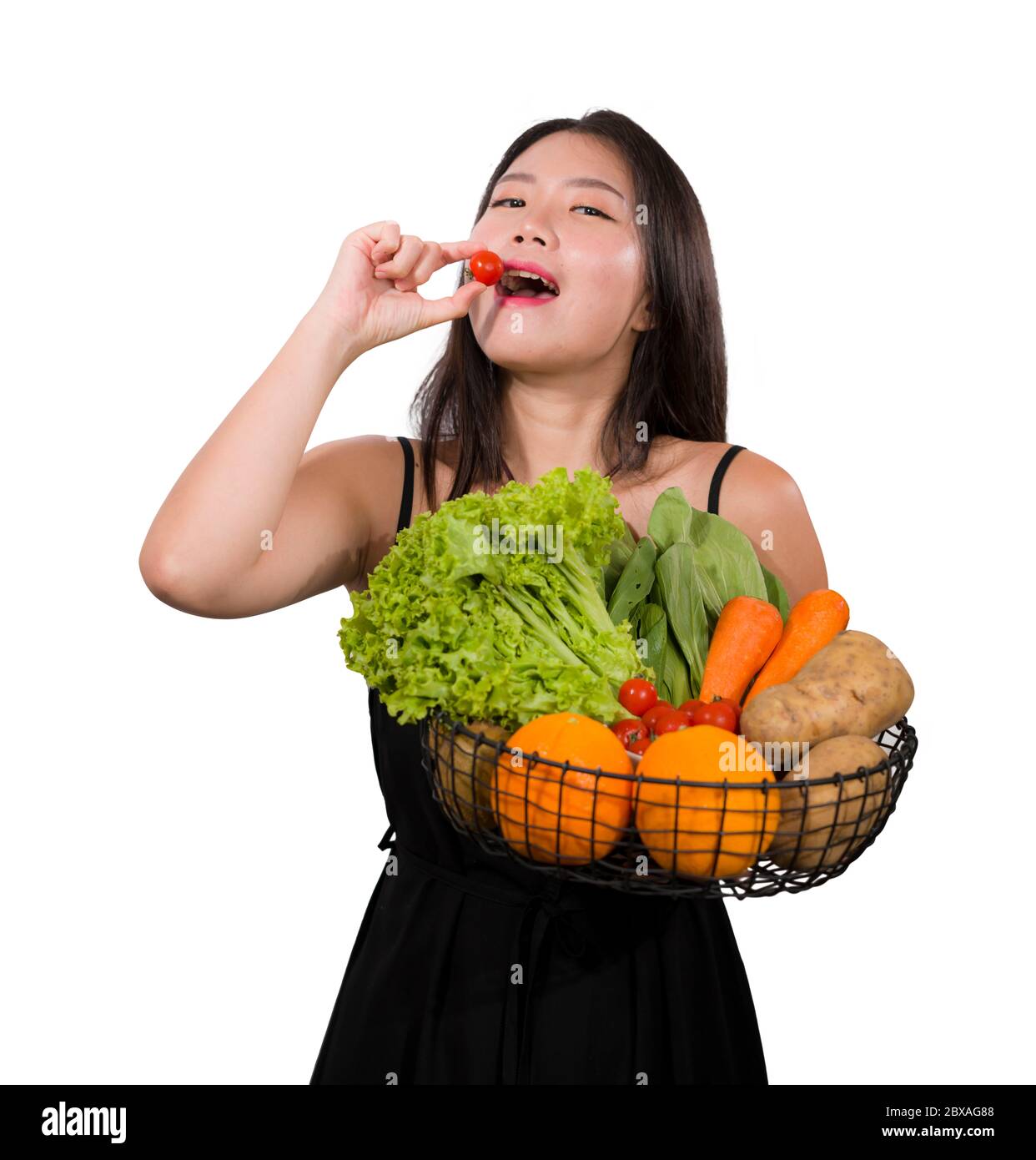 young happy and beautiful Asian Chinese woman holding basket full of ...