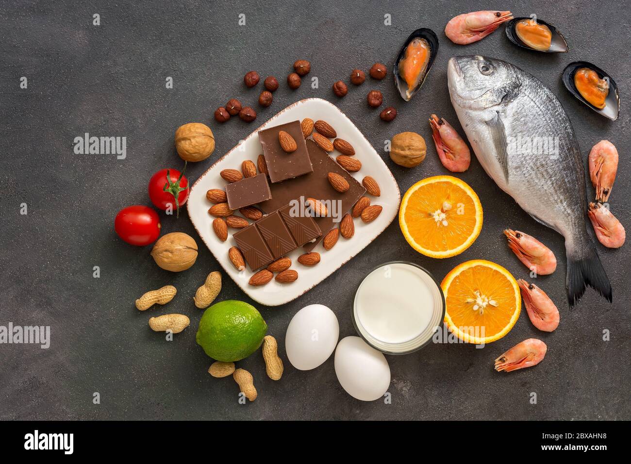 Food allergens. Seafood, milk, chocolate, nuts, citrus fruits, eggs. Allergic food concept. Top view, flat lay, copy space Stock Photo