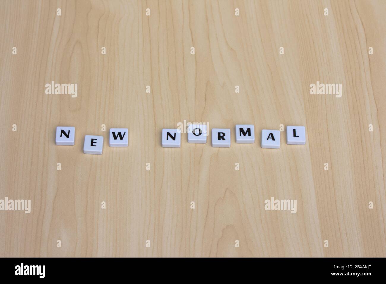 NEW NORMAL word on a wooden background. Concept of new normal after pandemic COVID-19. Stock Photo