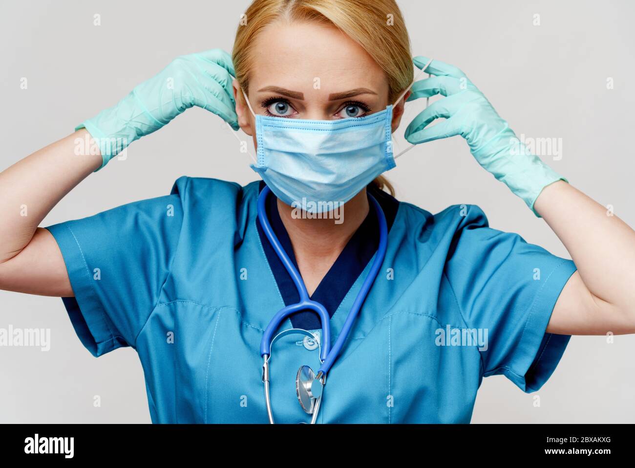 medical doctor nurse woman with stethoscope wearing protective mask and rubber or latex gloves Stock Photo