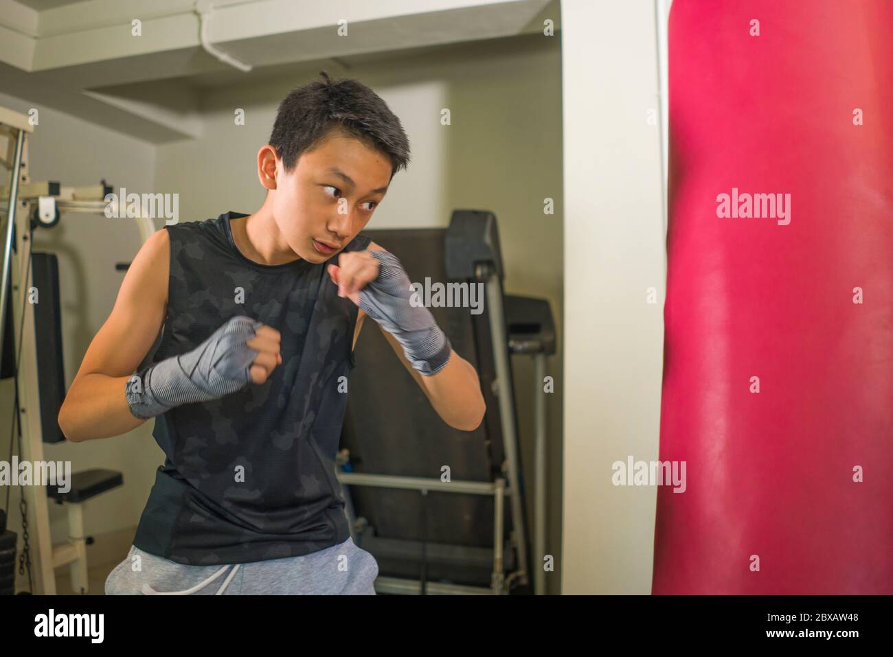 Asian American teenager boxing on gym . young handsome and fierce 13 or