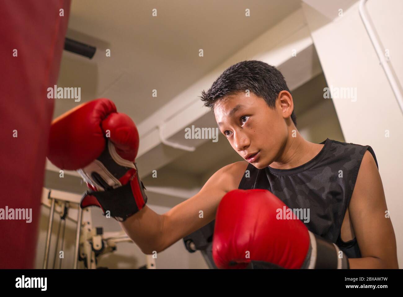 Asian American teenager boxing on gym . young handsome and fierce
